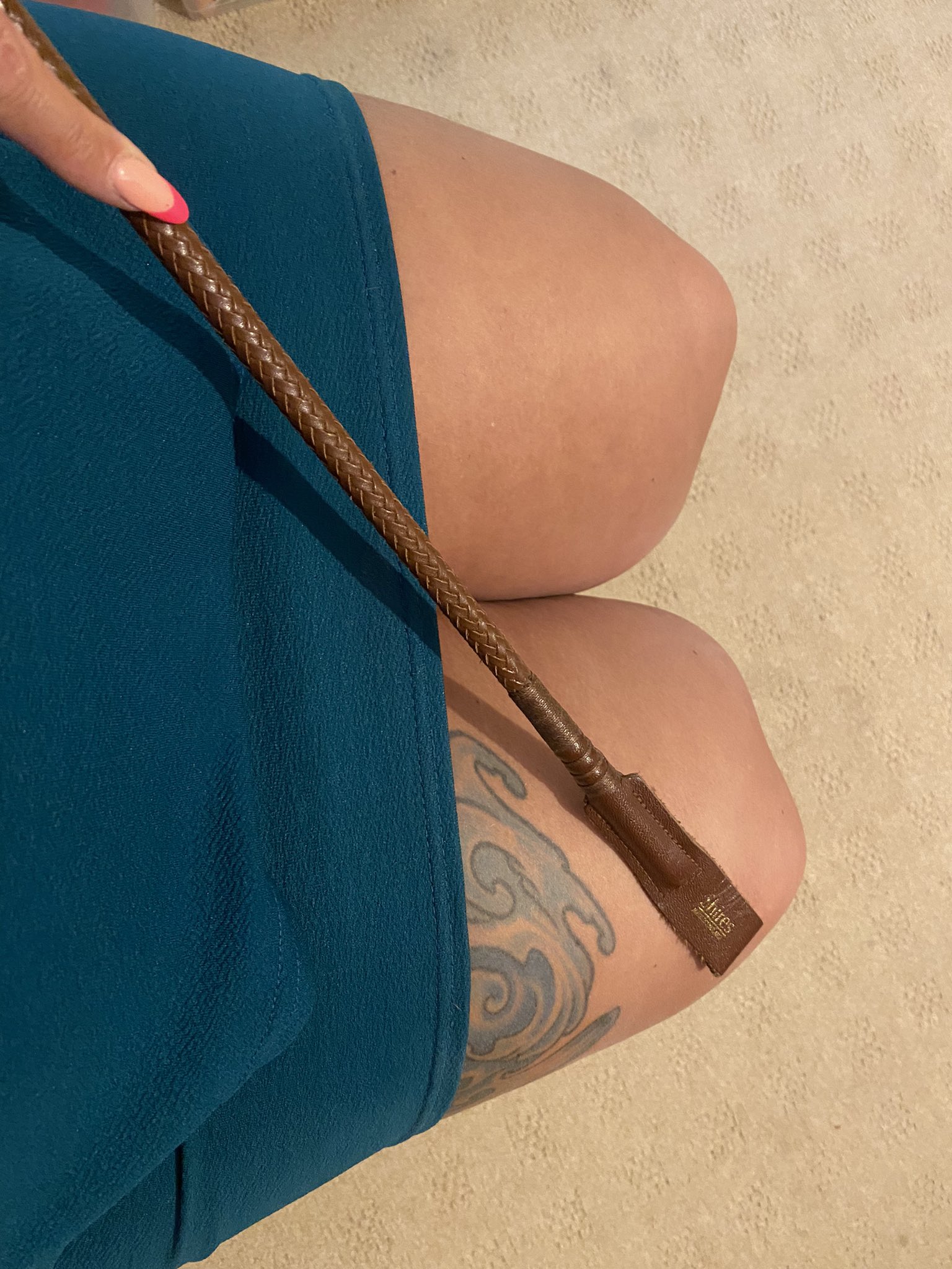 Fleshy thighs, short skirt and riding crop ready to punish a bottom